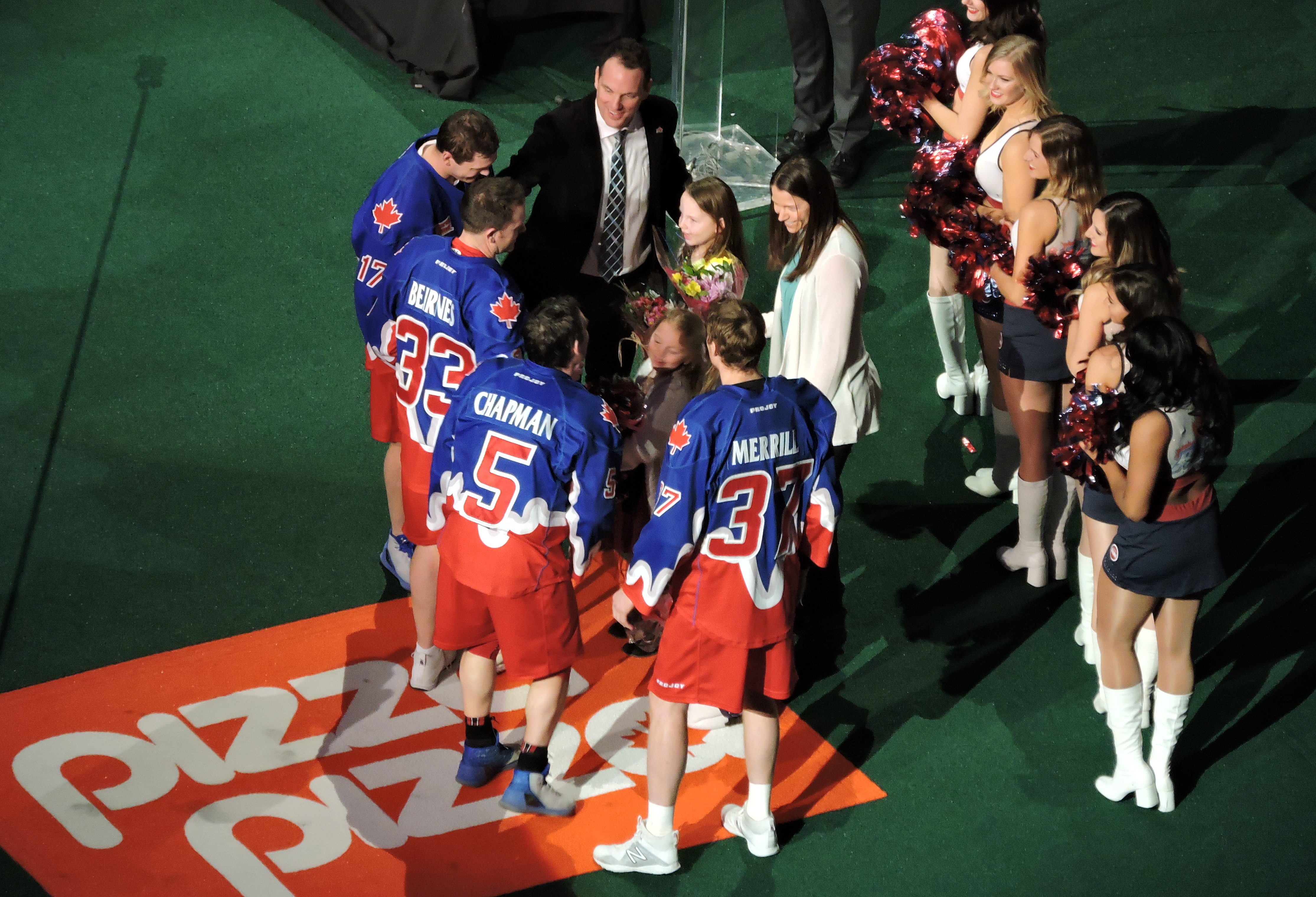 The Toronto Rock leadership team presents Stacey Doyle and her three daughters with flowers at her husband Colin's retirement ceremony. (Photo credit: Anna Taylor)