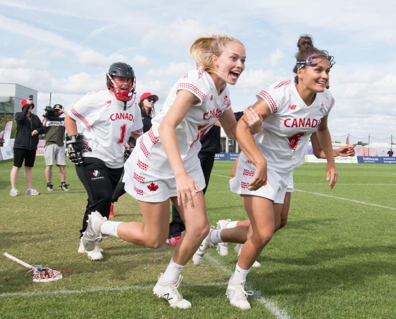 L-R; Allison Daley, Claire Mills, Danita Stroup run on to celebrate with their team at the end of the semi final win against Australia at the 2017 FIL Rathbones Women's Lacrosse World Cup at Surrey Sports Park, Guilford, Surrey, UK, 15th July 2017 (Credit Ady Kerry).